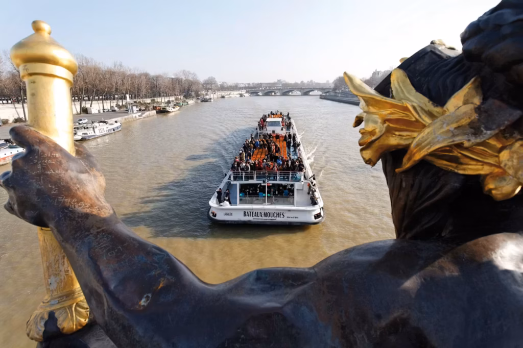 Bateaux Mouches tour boat on the Seine River, Paris, viewed from a statue